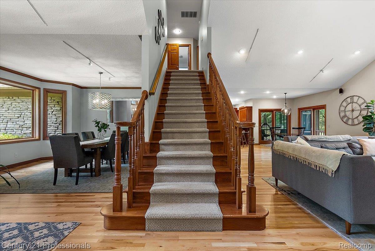 9867 Rainbow Ridge Drive Schoolcraft, MI 49087 - Photo 37 of 82 Central staircase with carpeted treads and wood railings