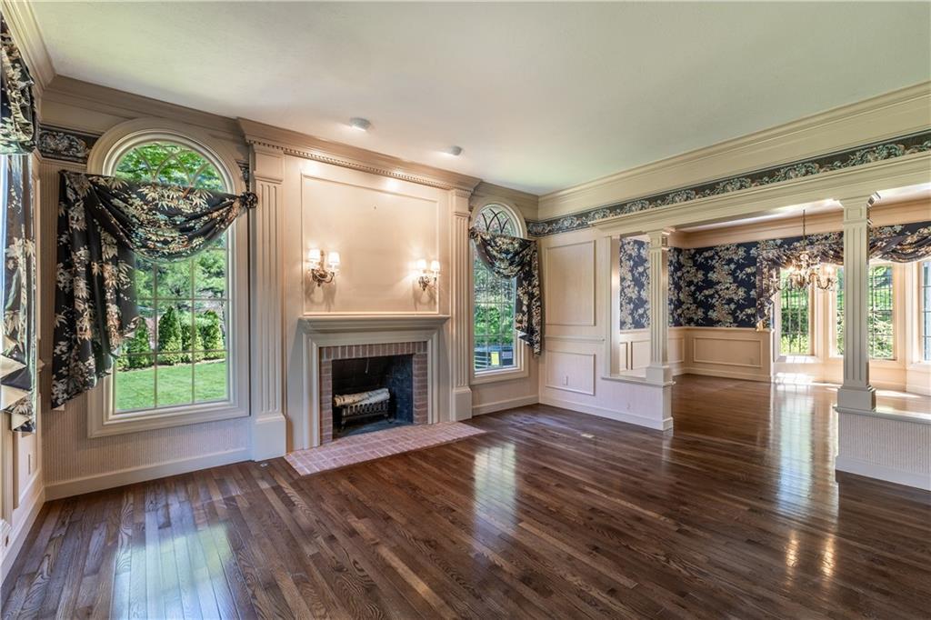 Gleaming Hardwood Floors, 12" Crown Molding, Chair Rail withWainscoting Detail, Recessed Lighting, Brick Faced Fireplace withMantel and Oentil Crown Molding Detail, 2 Front Facing Floor to CeilingWindows and 2 Side Facing Floor to Ceiling Windows withPalladium Windows Above, Schumacker Wallpaper, Hunter SuetteBlinds, Custom Made Drapery, Open to Dining Room with ColumnedEntrance!