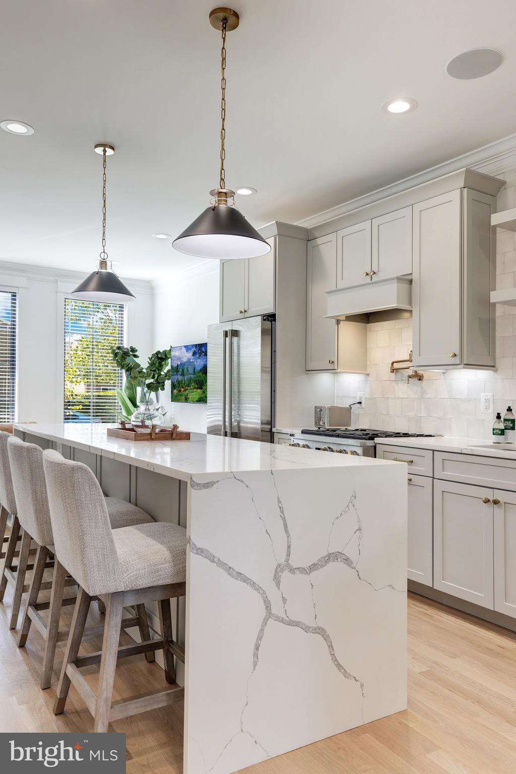 1415 Princess Street Alexandria, VA 22314 - Photo 14 of 63 a kitchen with stainless steel appliances granite countertop a stove a sink a refrigerator a dining table chairs and white cabinets