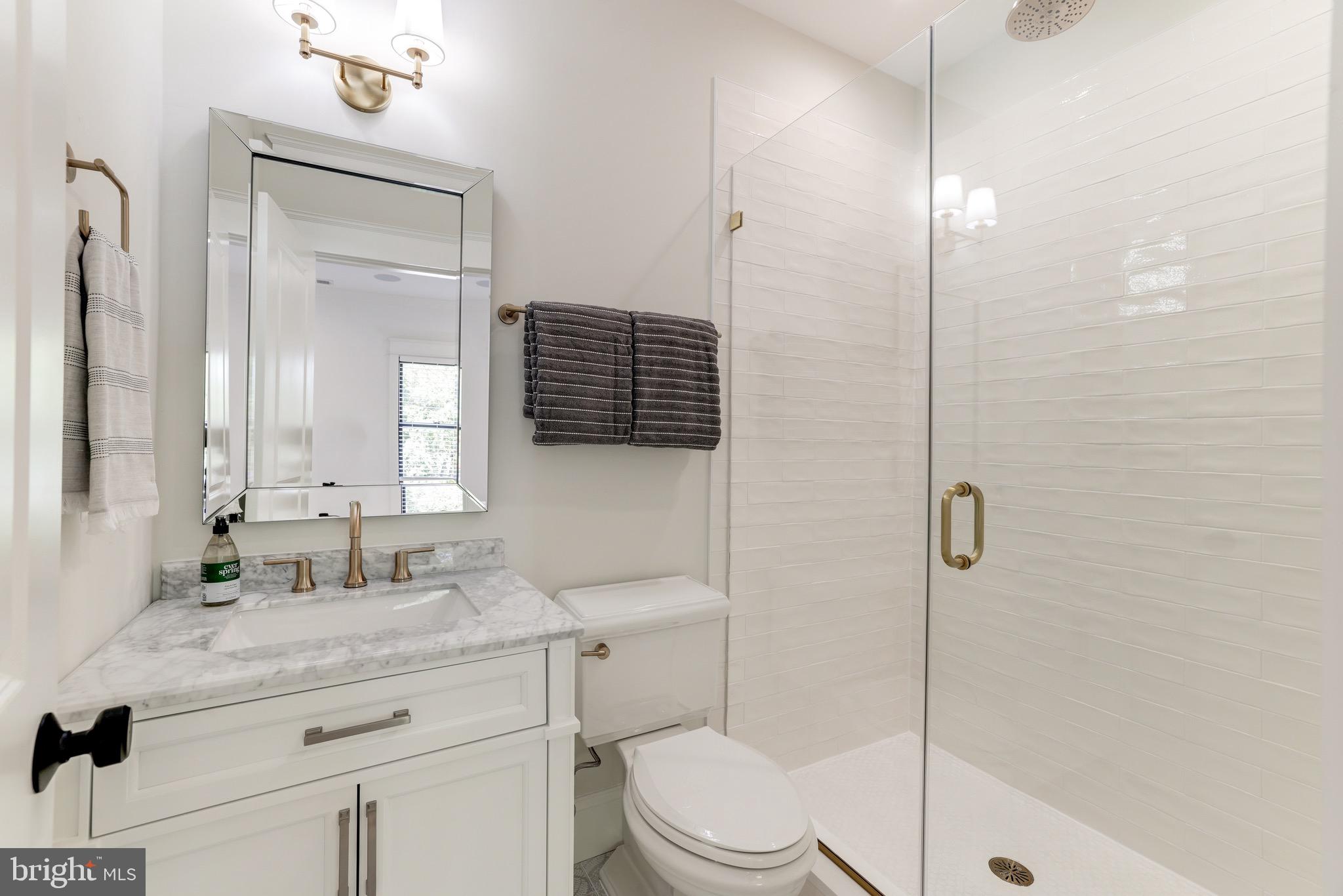 1415 Princess Street Alexandria, VA 22314 - Photo 41 of 63 a bathroom with a granite countertop sink toilet a mirror and shower