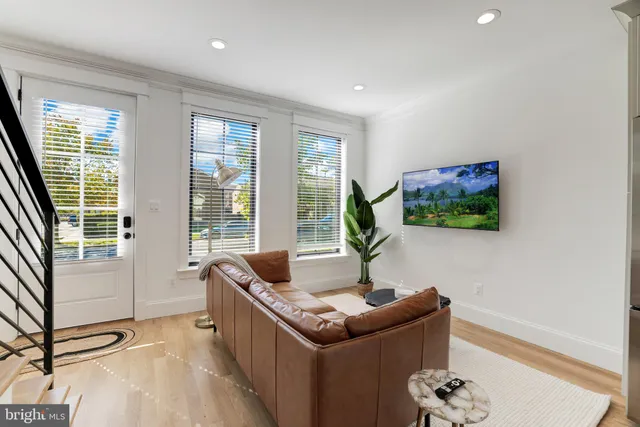 a large kitchen with kitchen island a refrigerator a stove a sink a dining table and chairs with wooden floor