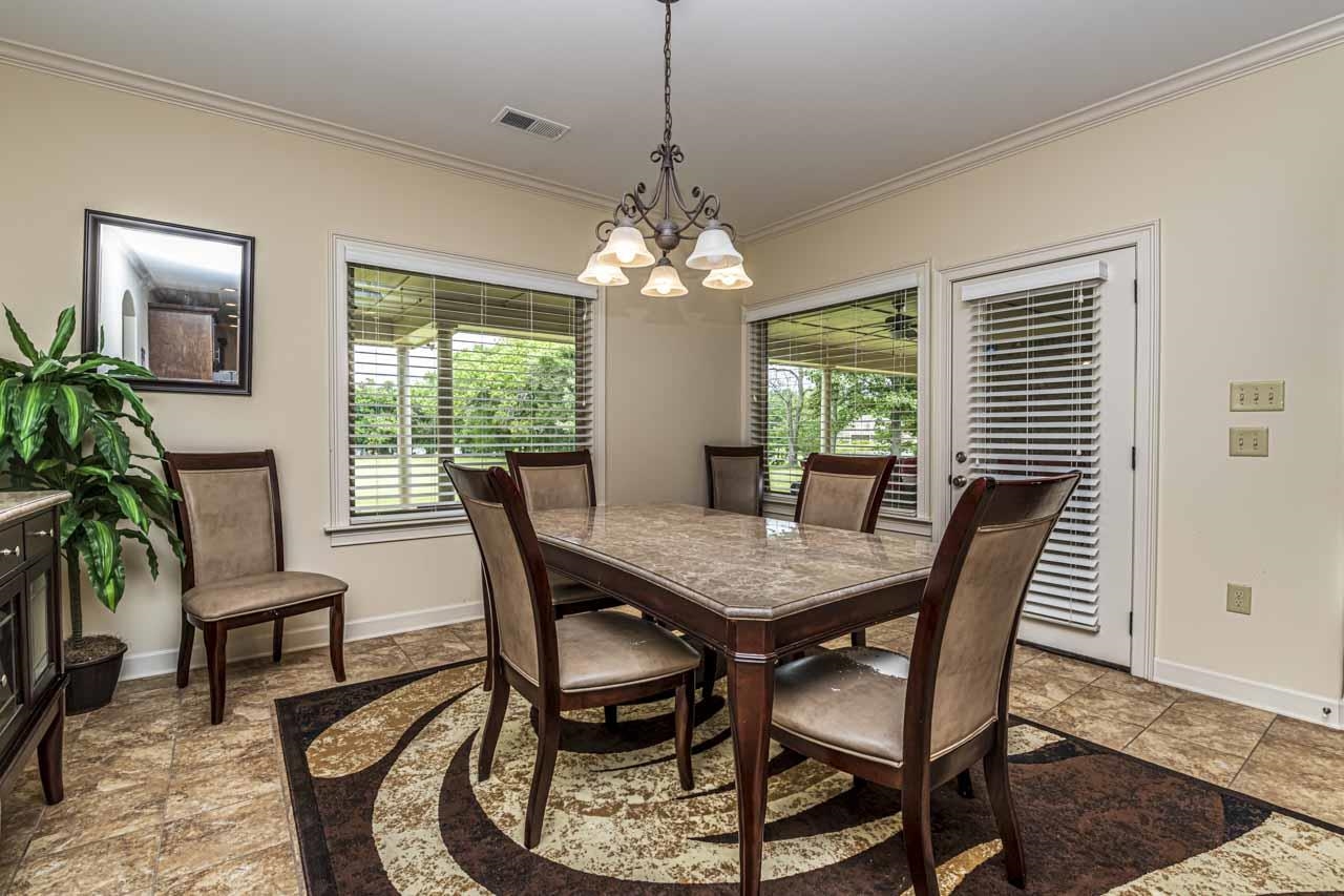 185 Belmont Road Mason, TN 38049 - Photo 12 of 38 Dining area featuring tile flooring, crown molding, and a chandelier