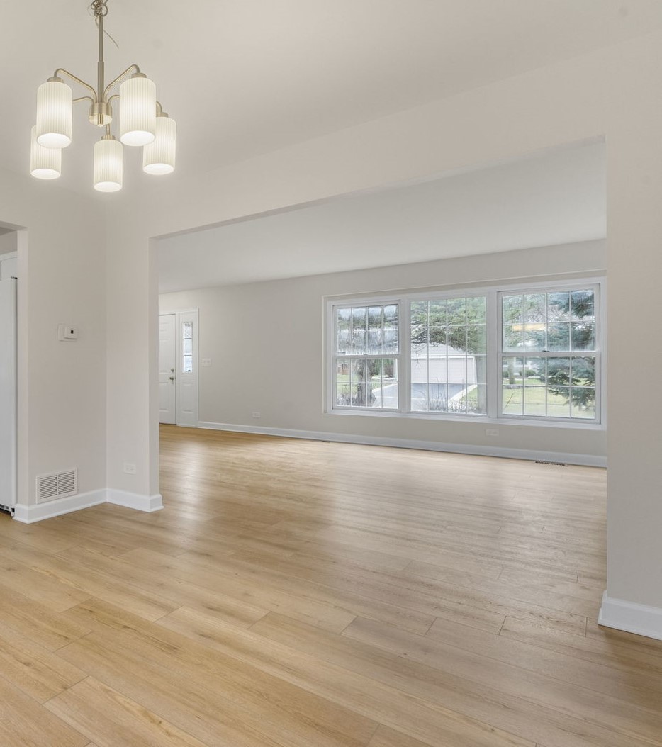 608 Carriage Hill Road Island Lake, IL 60042 - Photo 2 of 28 an empty room with wooden floor and windows
