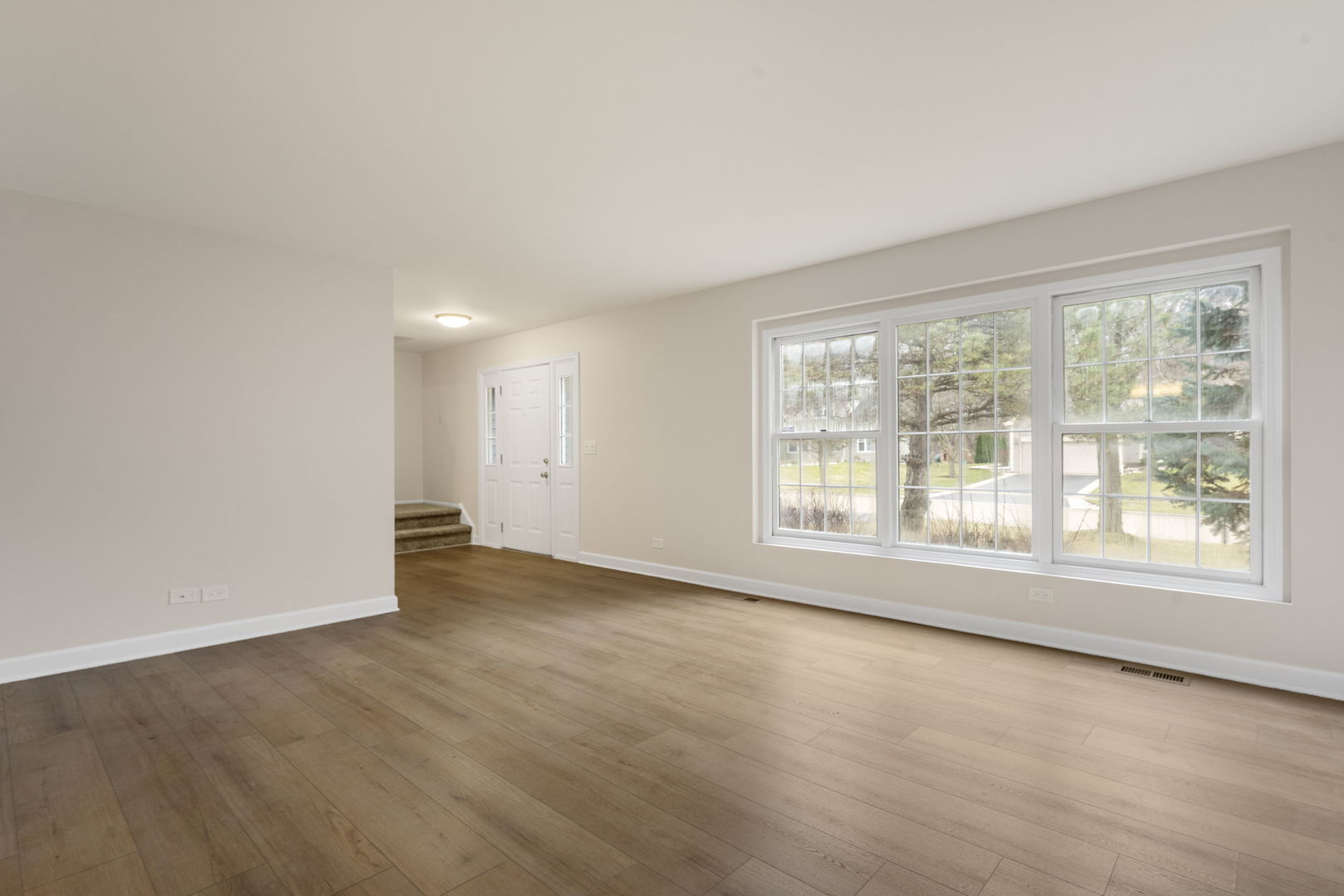 608 Carriage Hill Road Island Lake, IL 60042 - Photo 5 of 28 an empty room with wooden floor and windows