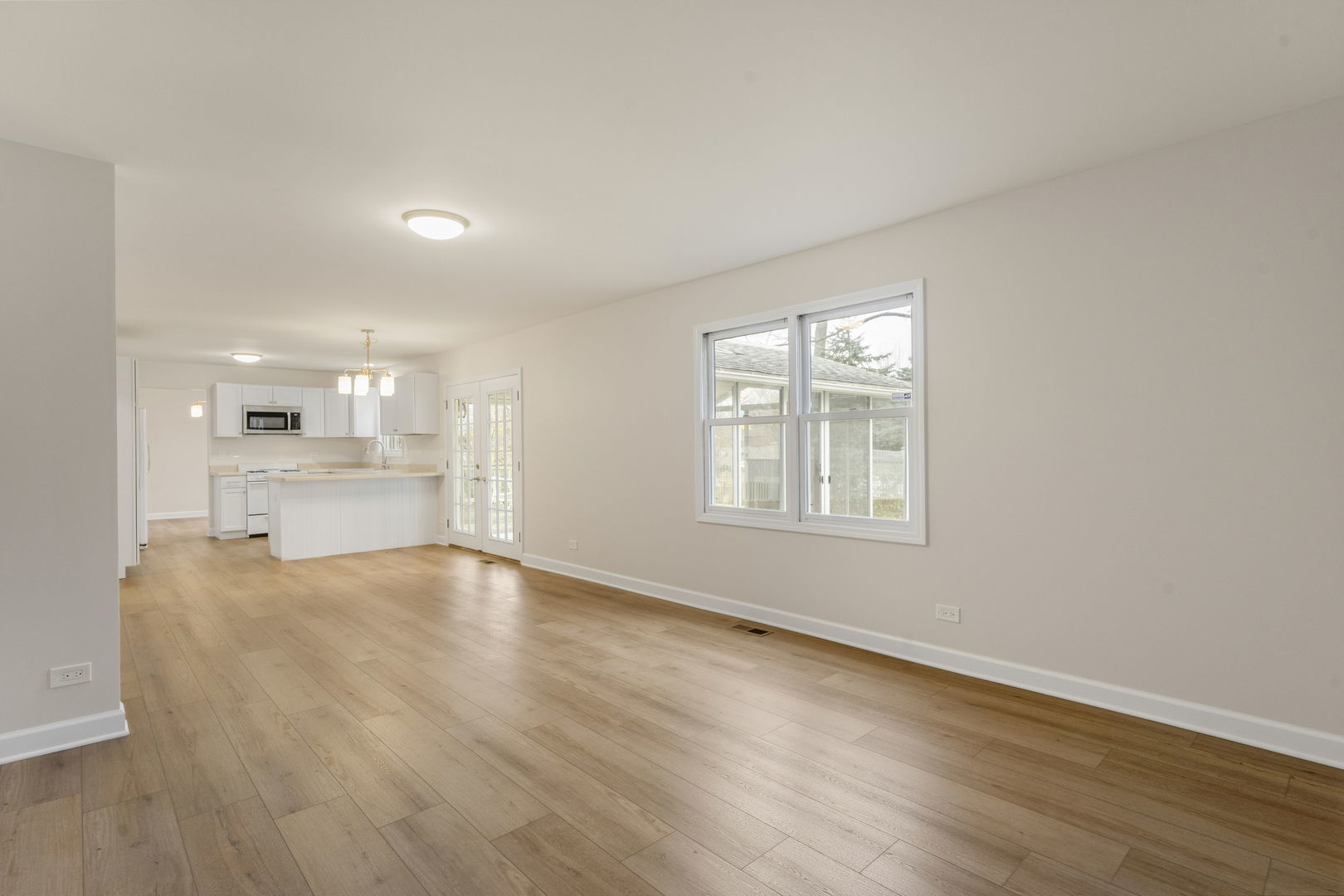 608 Carriage Hill Road Island Lake, IL 60042 - Photo 9 of 28 a view of an empty room with wooden floor and a window