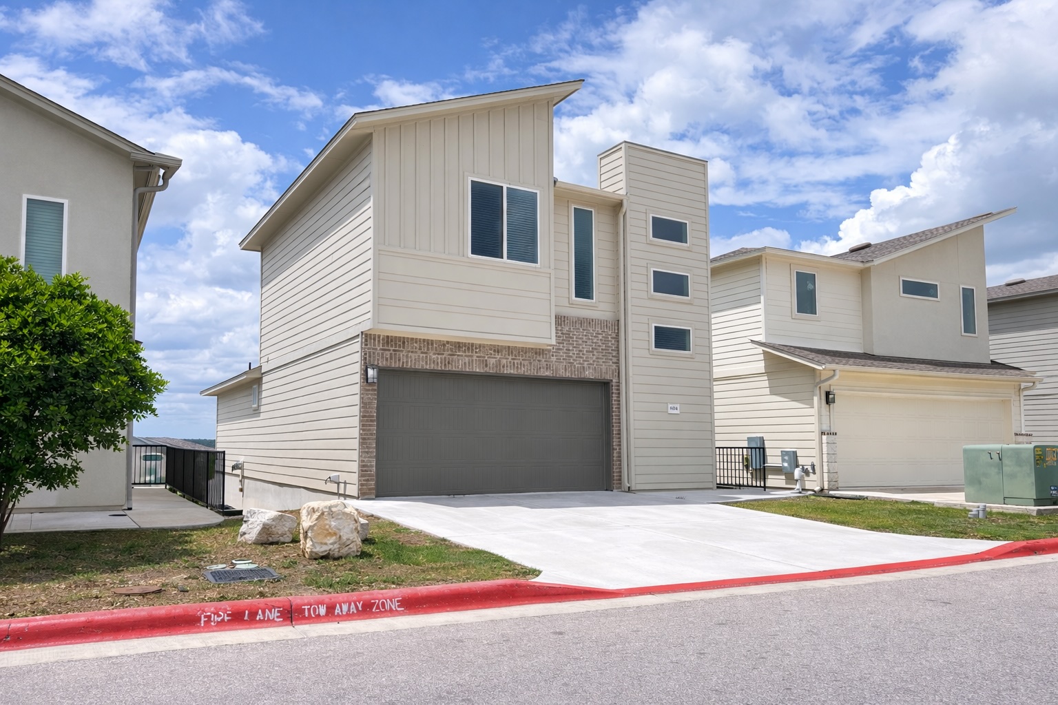6104 Steep Cactus Trail Austin, TX 78735 - Photo 1 of 17 The property features a contemporary architectural style with light-colored siding and a prominent attached garage with a dark door