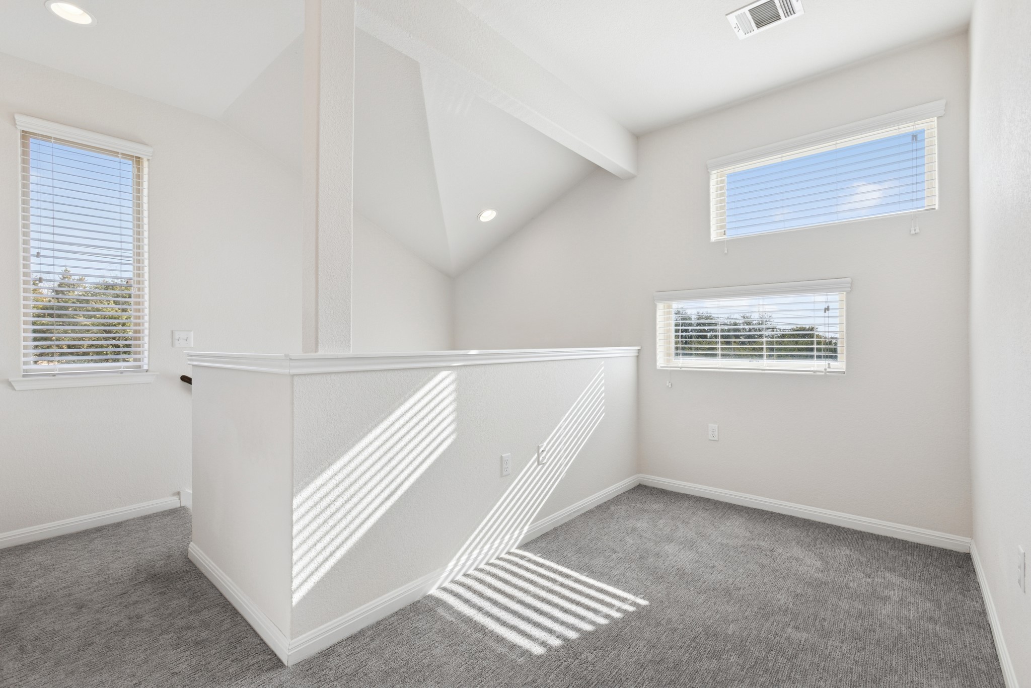 6104 Steep Cactus Trail Austin, TX 78735 - Photo 12 of 17 This bright interior space features recessed lighting, sloped ceilings, and carpeted flooring