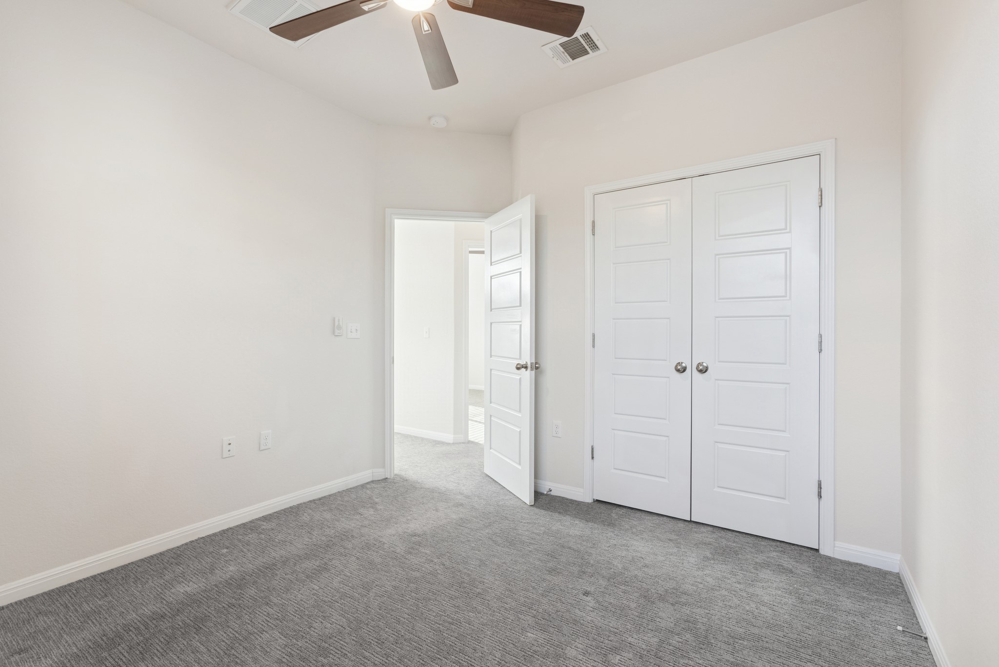 6104 Steep Cactus Trail Austin, TX 78735 - Photo 14 of 17 Room featuring light-colored walls, gray carpet, and a ceiling fan