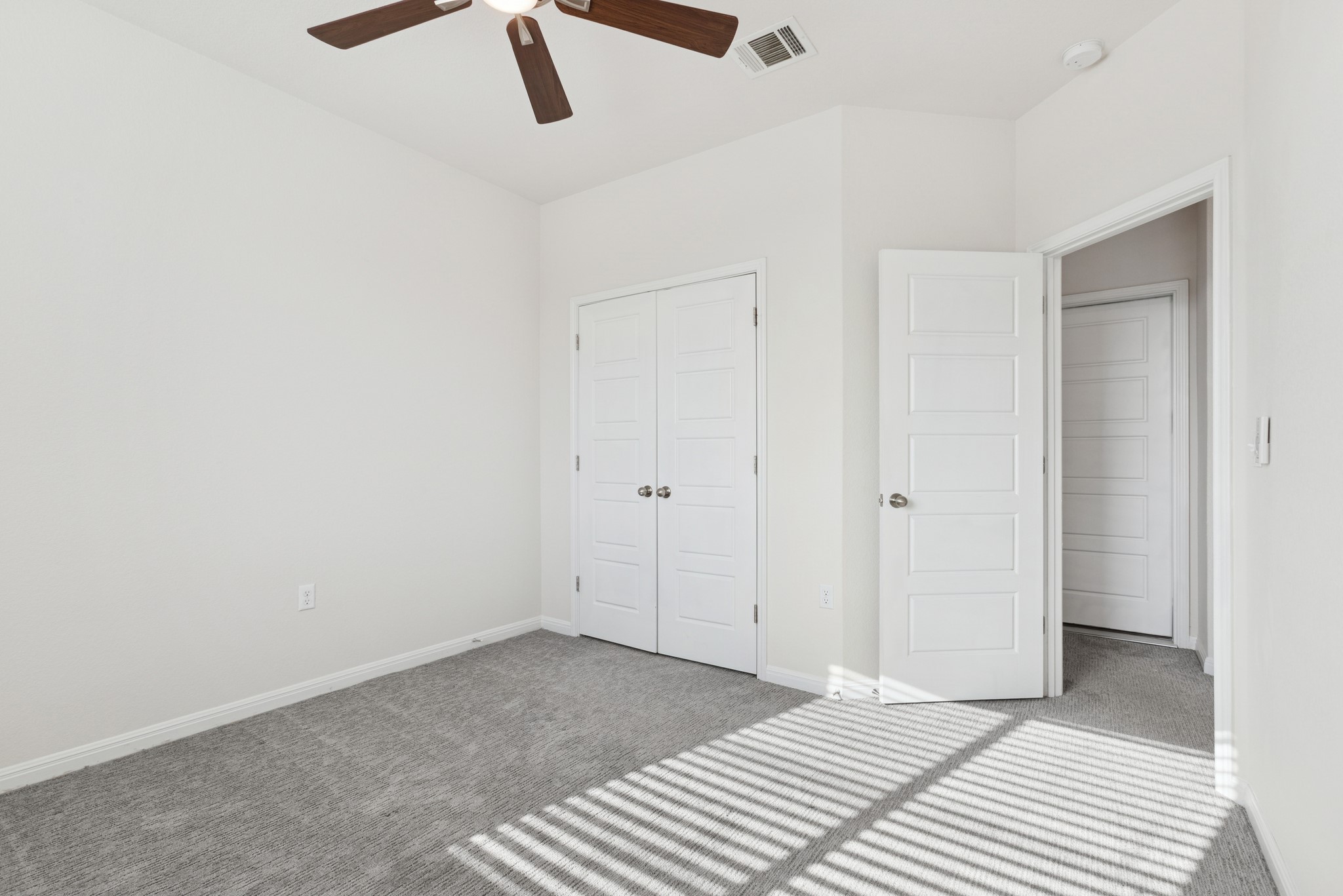 6104 Steep Cactus Trail Austin, TX 78735 - Photo 16 of 17 This space features light grey carpeting, white walls, and a ceiling fan with wooden blades