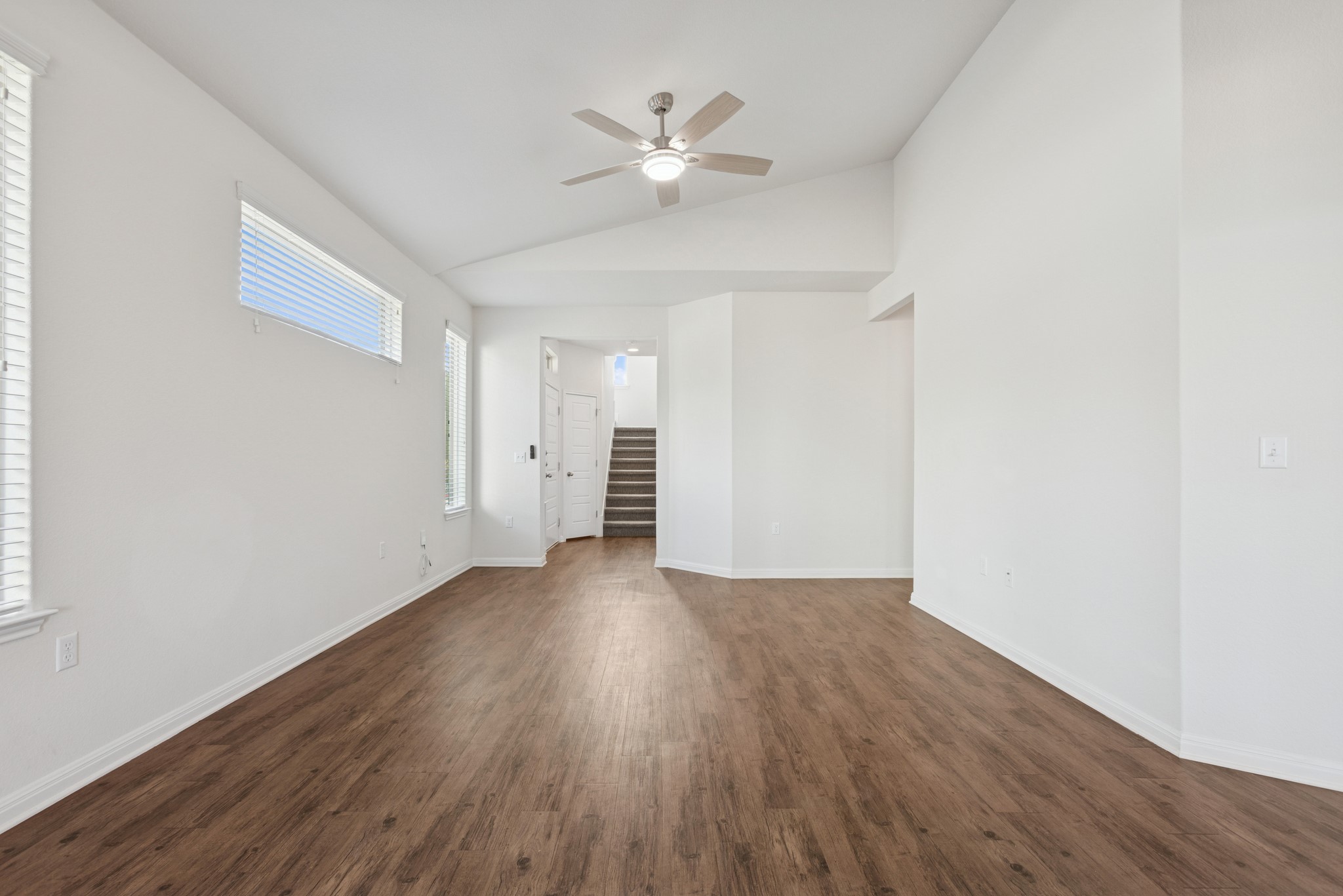 6104 Steep Cactus Trail Austin, TX 78735 - Photo 3 of 17 The property features an expansive open living area with rich wood-style flooring, white walls, and a ceiling fan, creating an inviting atmosphere