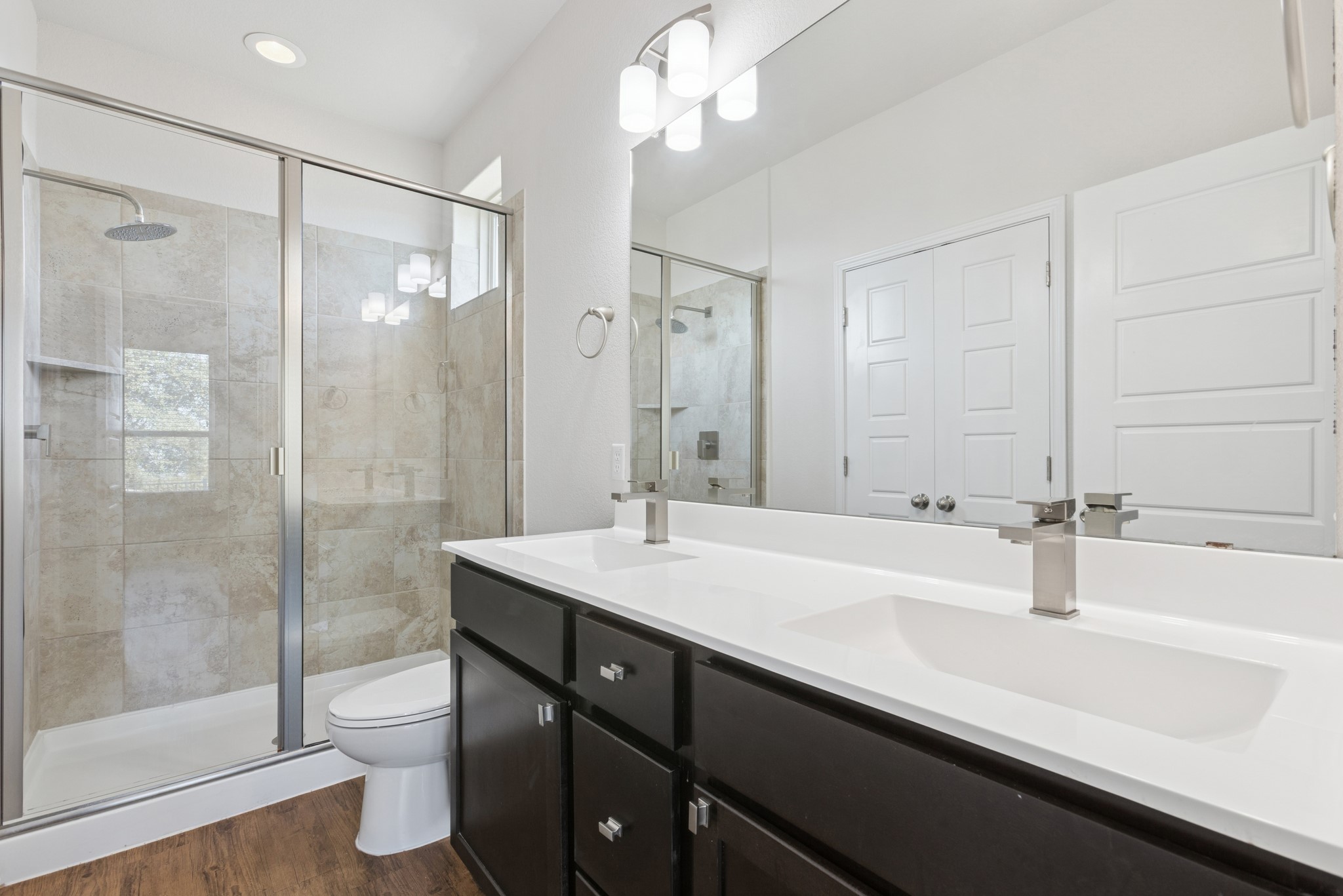 6104 Steep Cactus Trail Austin, TX 78735 - Photo 10 of 17 Bathroom featuring a dual vanity with white countertops, dark wood cabinetry, and a spacious walk-in shower with tile surround and glass enclosure