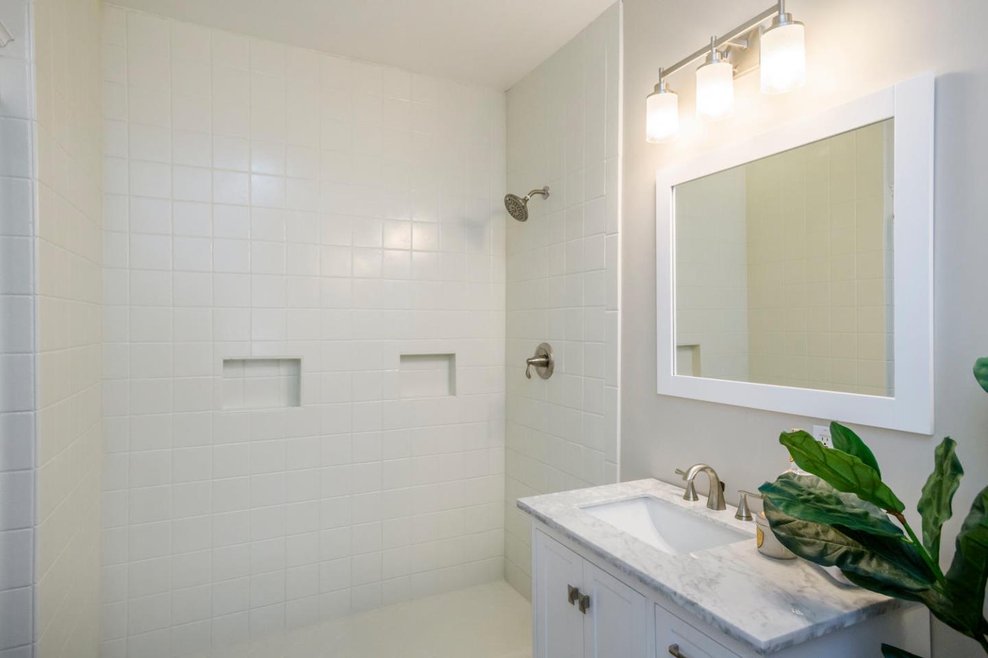 12 Dwight Road Burlingame, CA 94010 - Photo 16 of 34 a bathroom with a sink a mirror and a shower