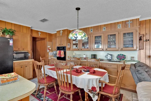 a dining room with furniture a chandelier and wooden floor