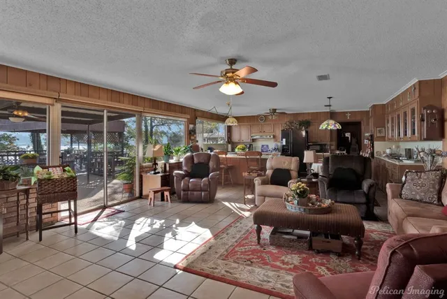 a living room with furniture kitchen view and a large window
