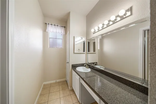 a spacious bathroom with a granite countertop sink a mirror and a shower
