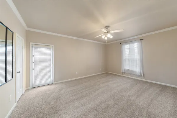 an empty room with chandelier fan and windows