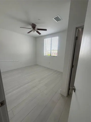 a view of a hallway with wooden floor and entryway