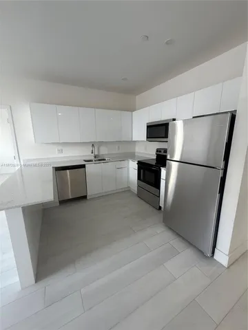 a kitchen with stainless steel appliances a refrigerator sink and microwave