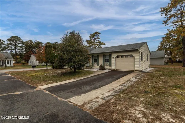a front view of a house with a yard and trees
