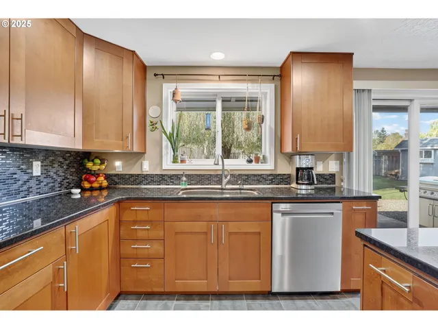 a kitchen with kitchen island granite countertop a sink window and cabinets