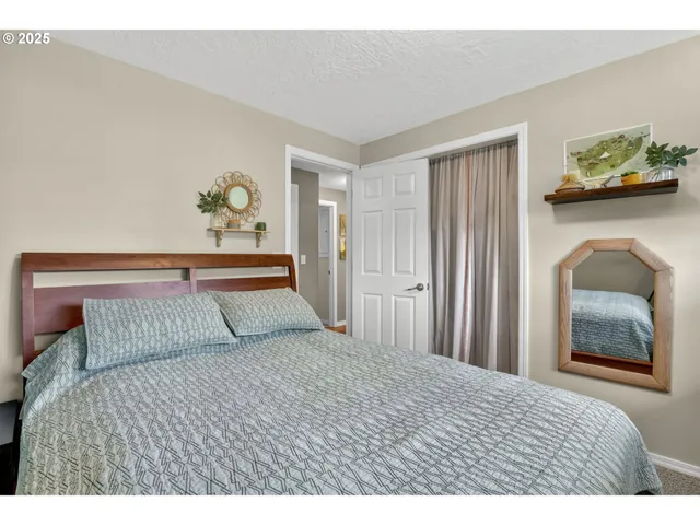 a bedroom with a bed and painting on the wall