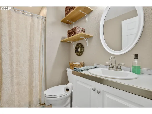 a bathroom with a sink vanity mirror and toilet