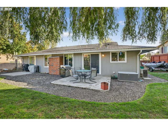a view of backyard of house with outdoor seating barbeque oven and trees