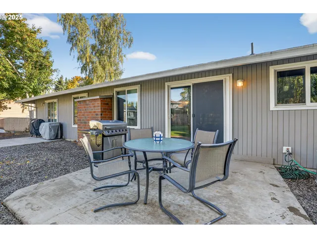 a view of a house with backyard and sitting area