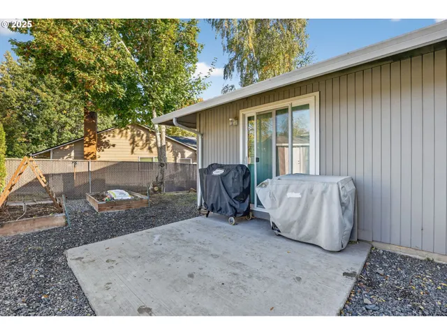 a view of a backyard with table and chairs and a barbeque