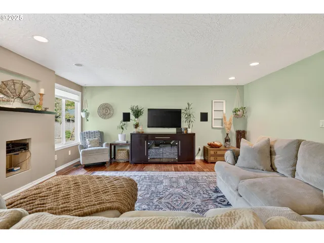 a living room with furniture a flat screen tv and a fireplace