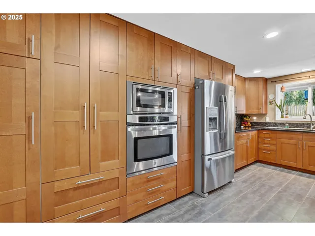 a kitchen with granite countertop stainless steel appliances and refrigerator