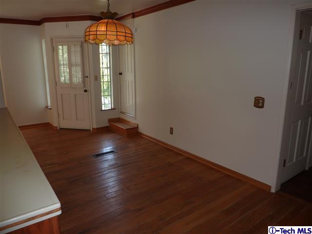 Undisclosed Address Pasadena, CA 91105 - Photo 19 of 50 an empty room with wooden floor chandelier and windows