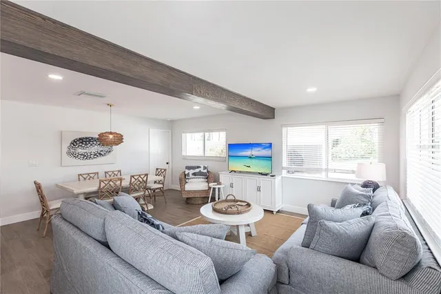 a living room with furniture kitchen view and a large window