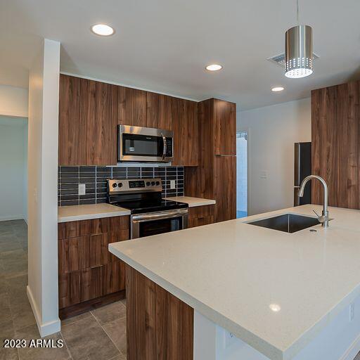 6227 North 13th Place, Unit 1 Phoenix, AZ 85014 - Photo 3 of 16 a kitchen with stainless steel appliances wooden cabinets a stove a sink and a refrigerator