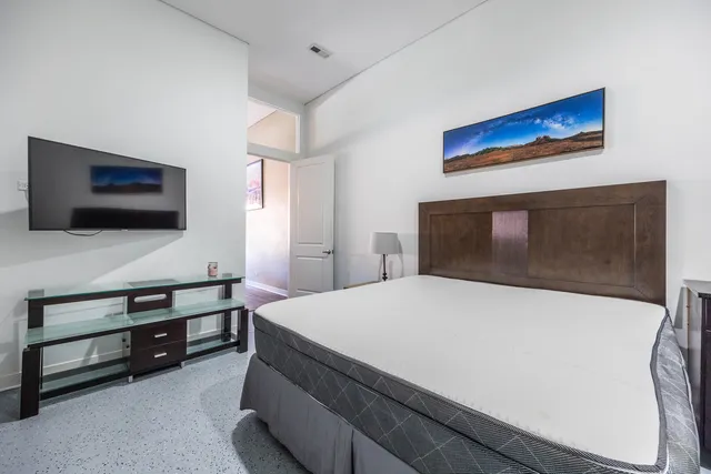 a bedroom with a bed and a flat screen tv