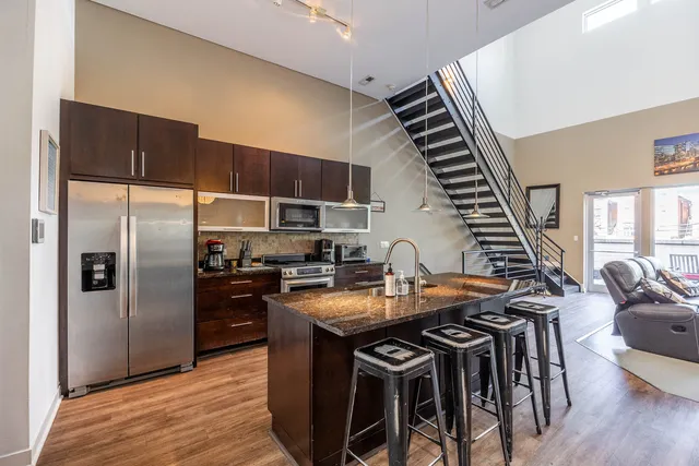 a kitchen with stainless steel appliances granite countertop a sink a stove and refrigerator
