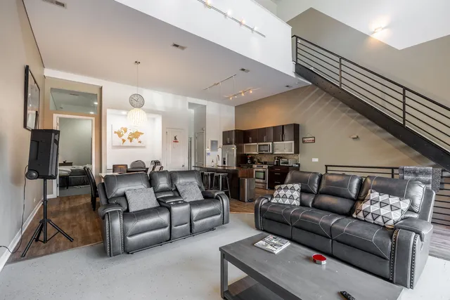 a living room with furniture kitchen view and a flat screen tv