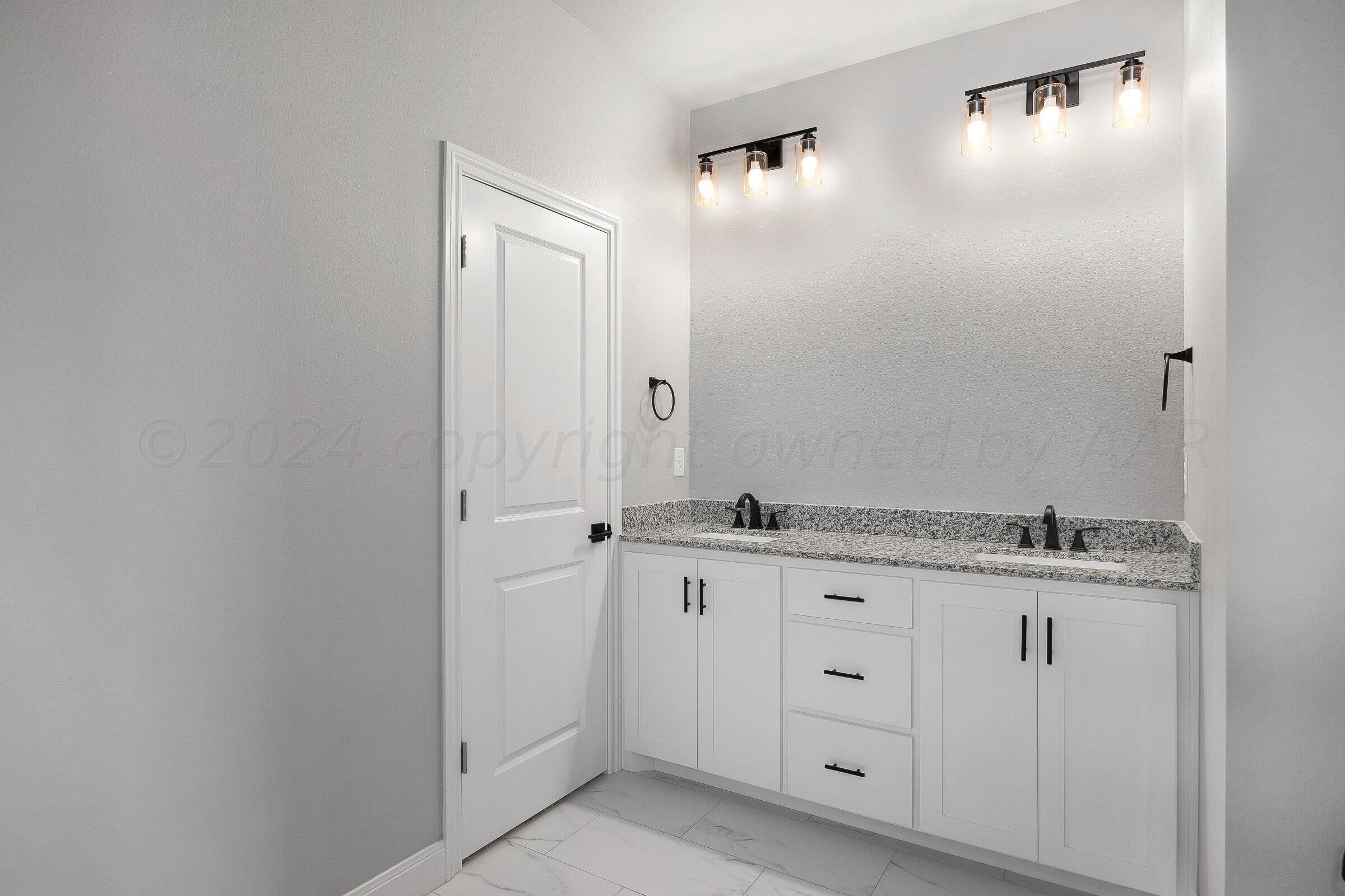 7501 John Thomas Street Amarillo, TX 79119 - Photo 17 of 30 a spacious bathroom with a granite countertop sink and a mirror
