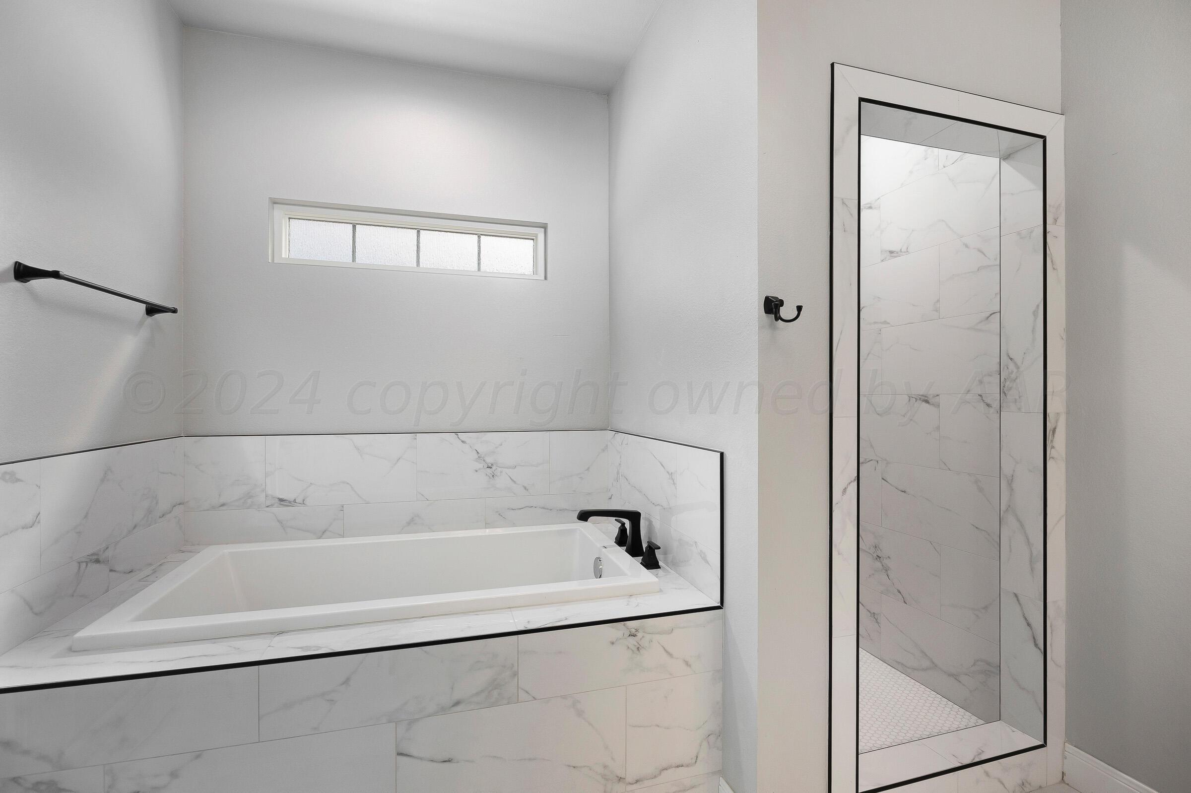 7501 John Thomas Street Amarillo, TX 79119 - Photo 18 of 30 a white bath tub sitting next to a window