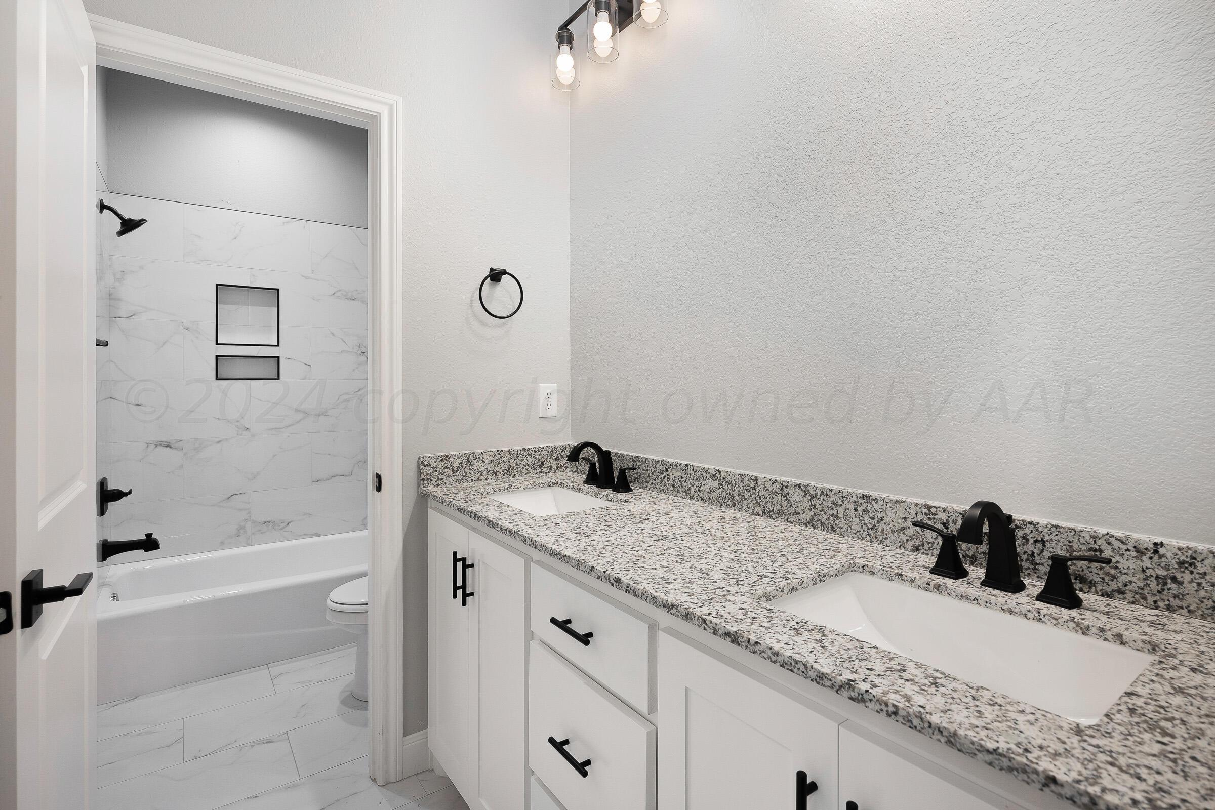 7501 John Thomas Street Amarillo, TX 79119 - Photo 23 of 30 a bathroom with a granite countertop sink and a mirror