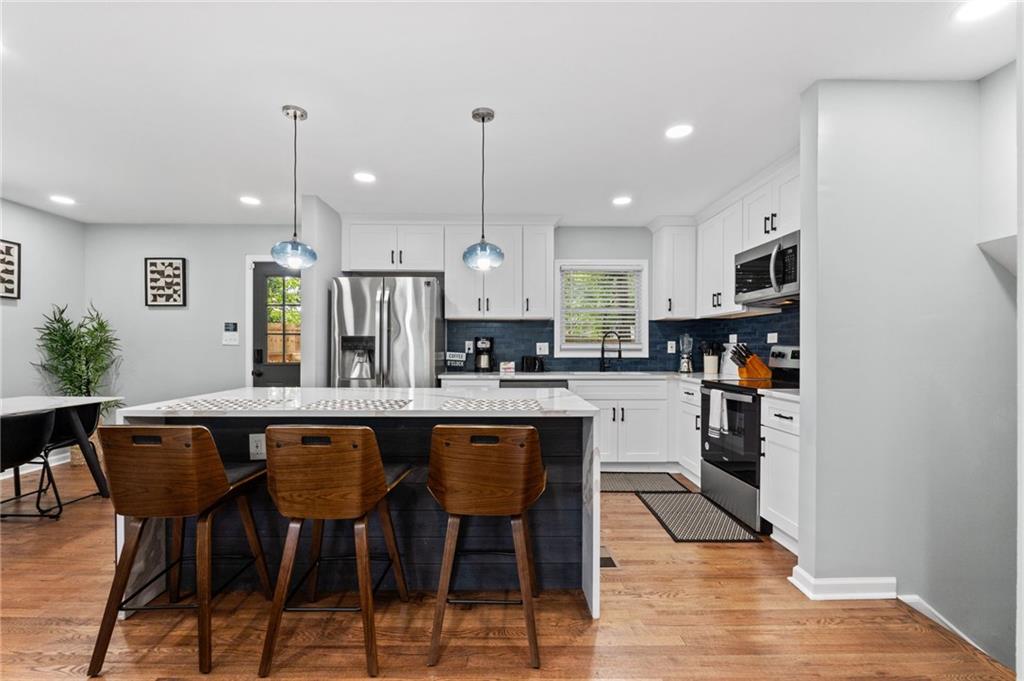 1467 Timms Circle Southeast Atlanta, GA 30316 - Photo 5 of 19 a kitchen with stainless steel appliances a dining table chairs refrigerator and microwave