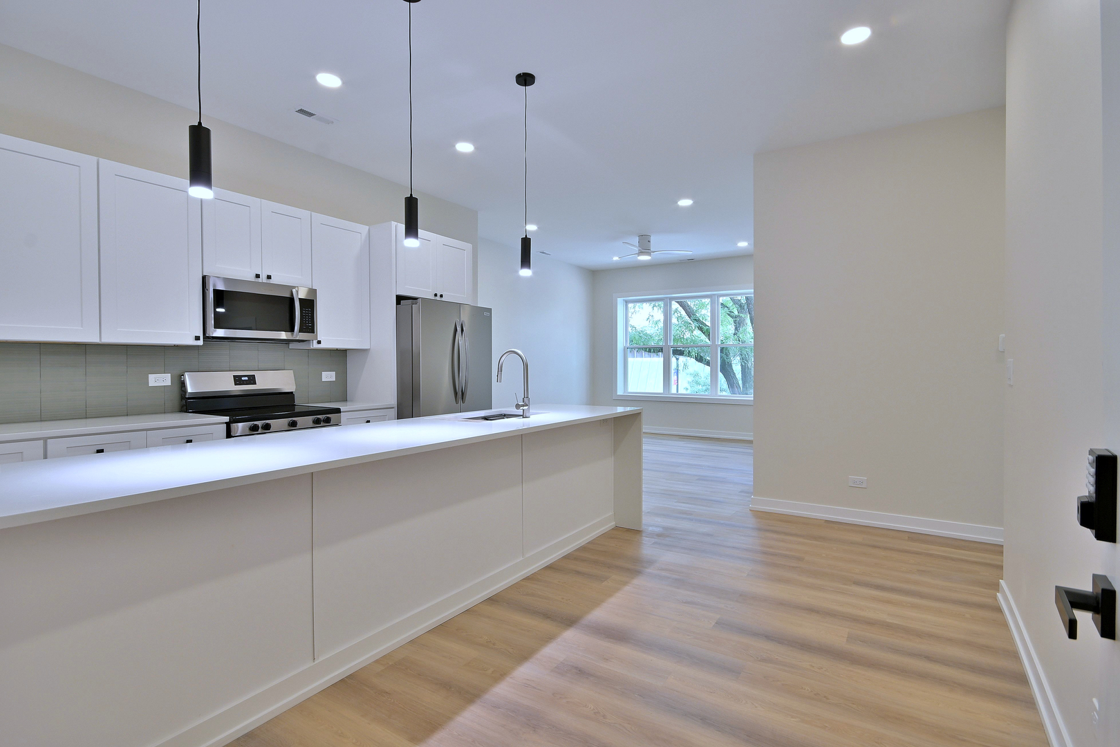 7518 Madison Street, Unit E Forest Park, IL 60130 - Photo 2 of 30 a large kitchen with stainless steel appliances a large counter top a stove and a wooden floors