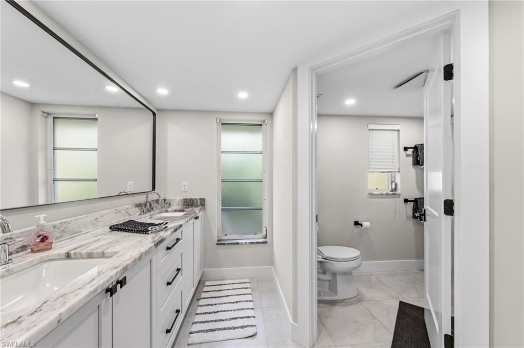 4724 Riverside Drive Estero, FL 33928 - Photo 23 of 44 a bathroom with a granite countertop sink a toilet and shower