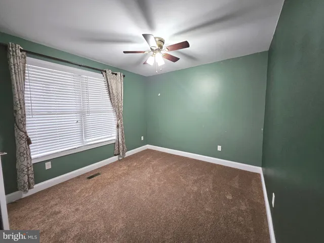an empty room with closet and fan