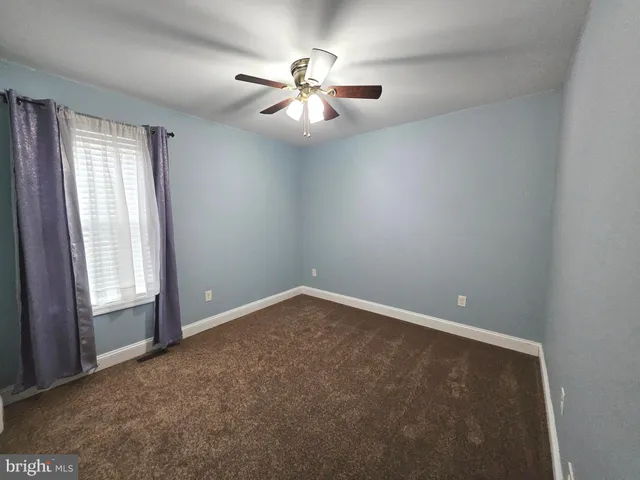 an empty room with closet and a chandelier fan