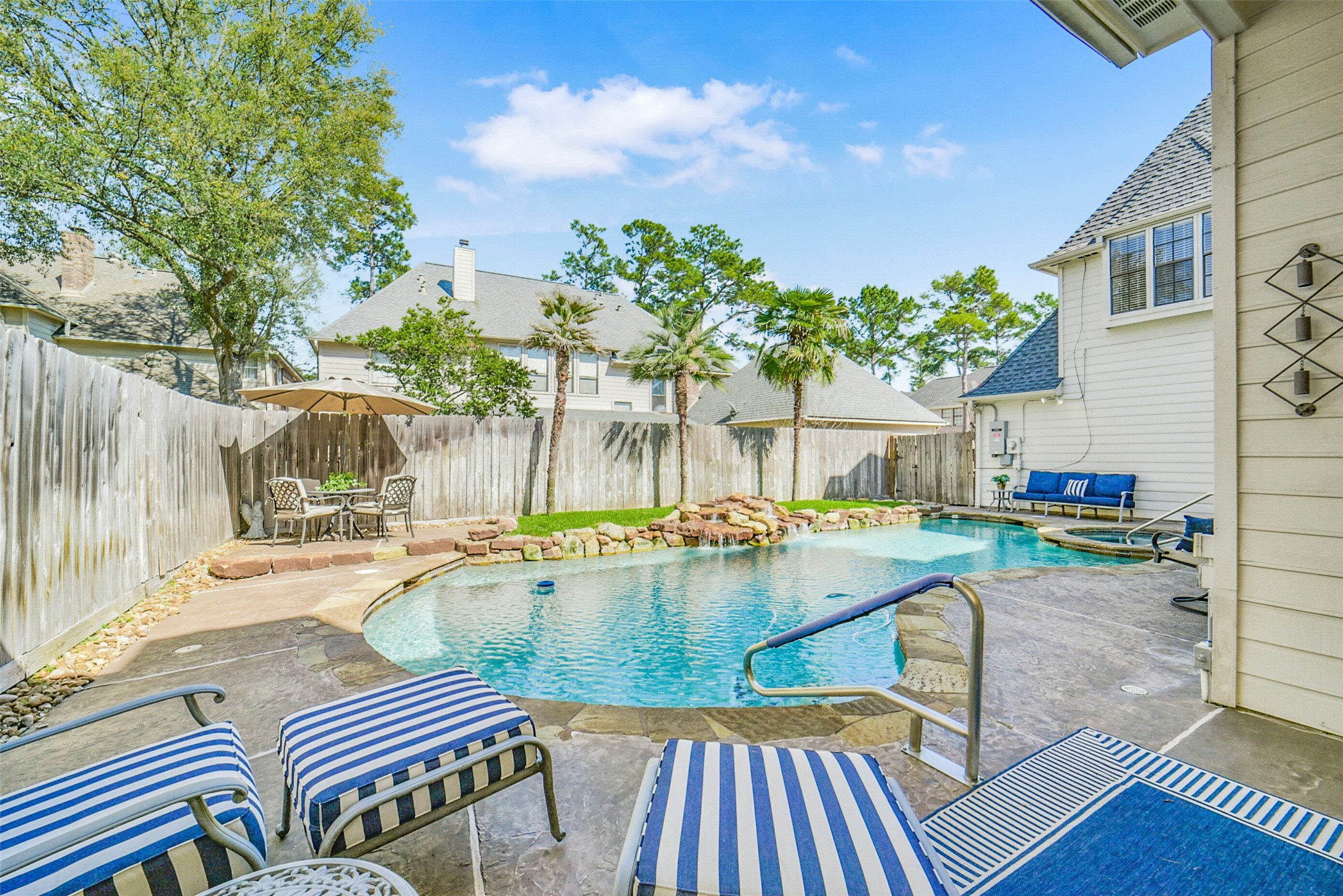 17302 Atherington Place Spring, TX 77379 - Photo 45 of 50 Resort-style backyard with heated PebbleTec pool, spa, and waterfall feature.