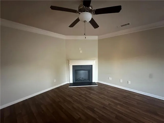 an empty room with wooden floor a ceiling fan and closet