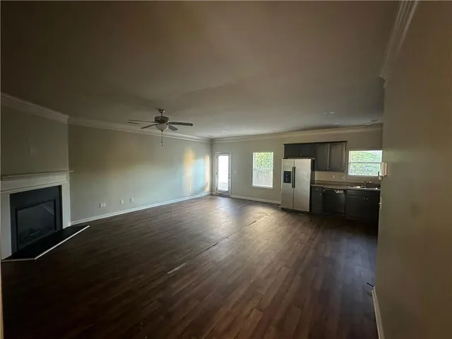 an empty room with windows and fireplace