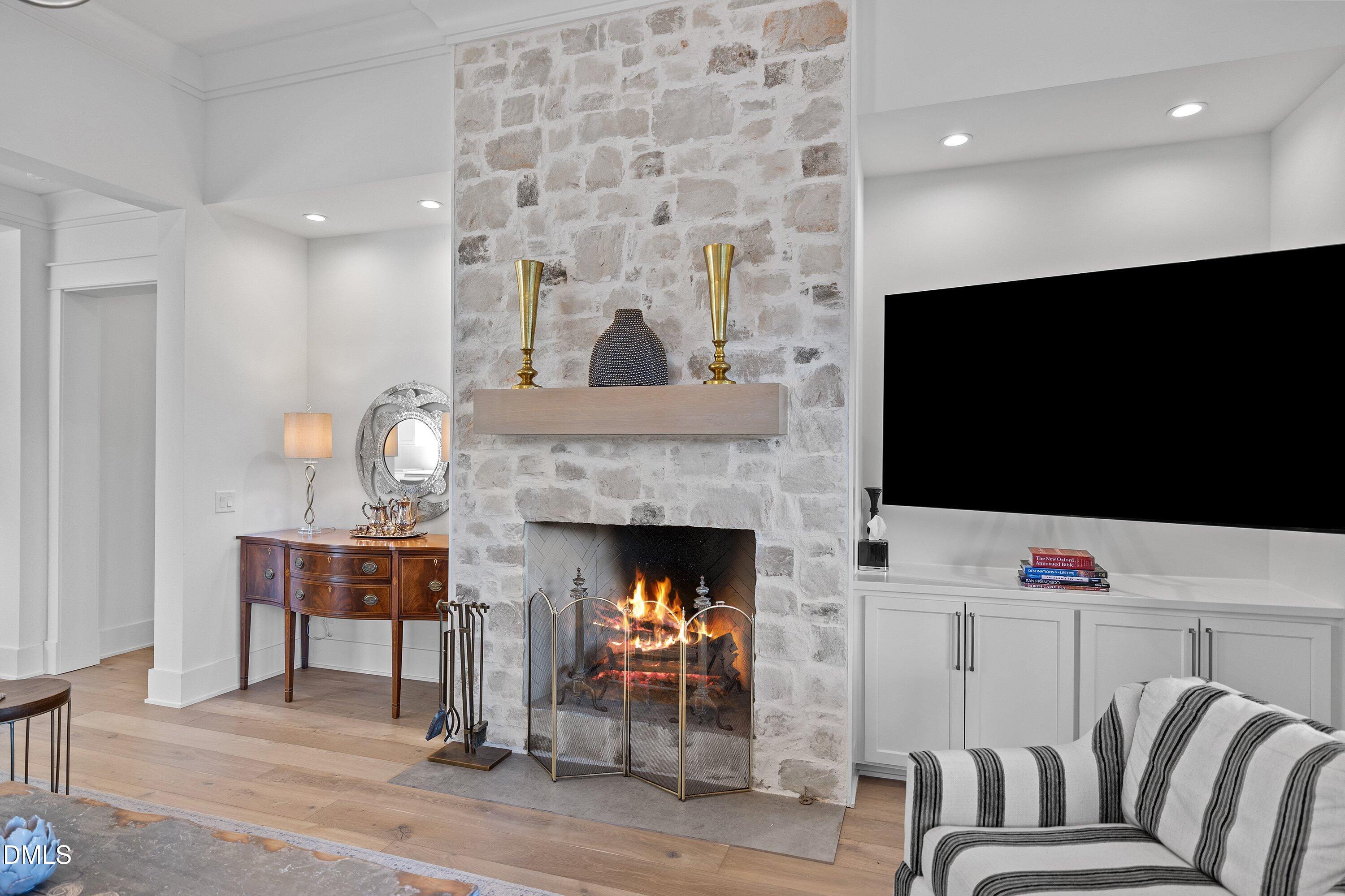 906 Brooks Avenue Raleigh, NC 27607 - Photo 25 of 64 a living room with furniture a flat screen tv and a fireplace