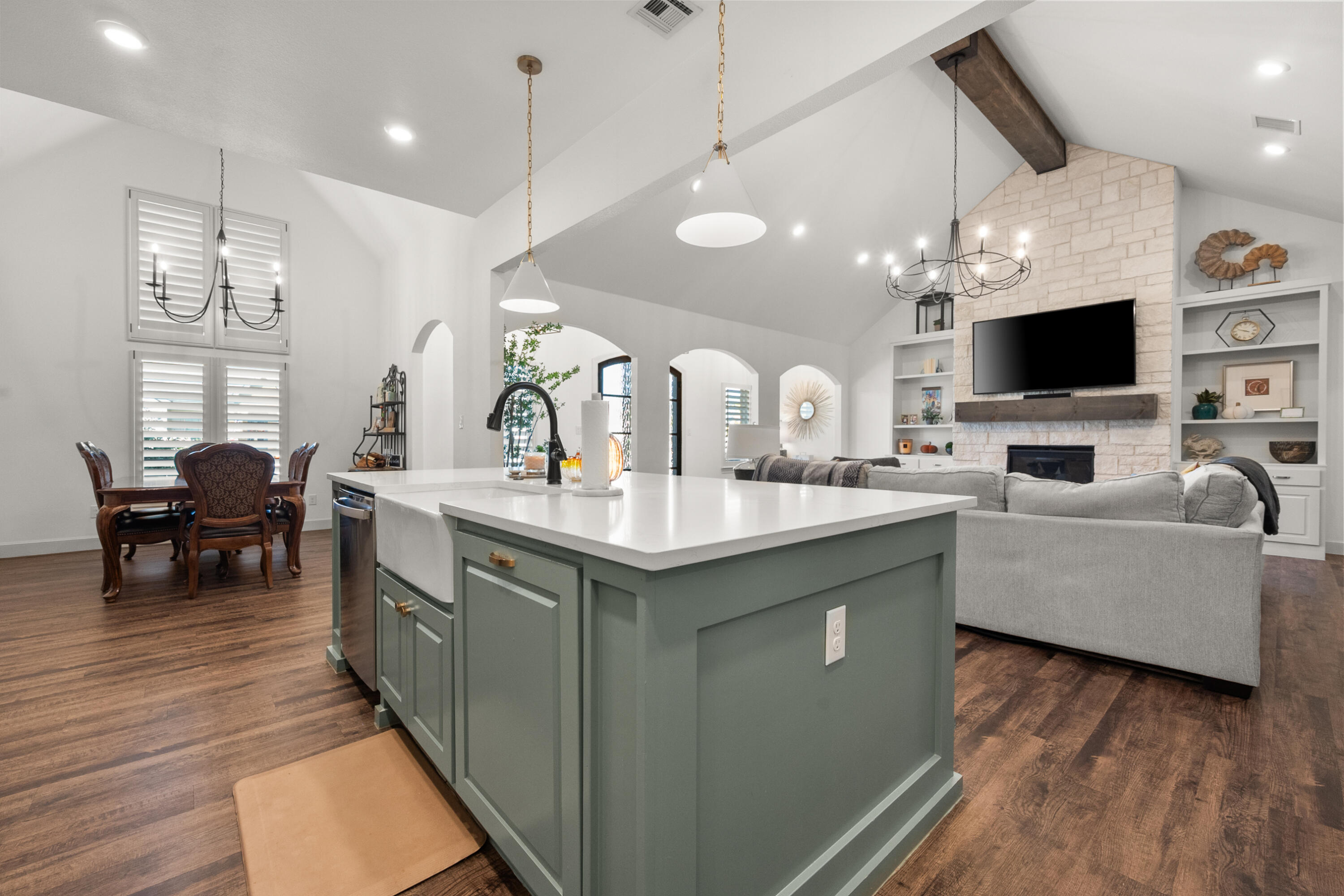 4509 140th Street Lubbock, TX 79424 - Photo 14 of 41 a large living room with stainless steel appliances granite countertop couches a fireplace a flat screen tv and a large window with wooden floor
